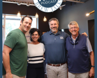 Four people stand smiling with arms around each other beneath a Roswell Brew Talks RBT Podcast sign in a modern, warmly lit room with exposed ceiling beams and hanging lights.